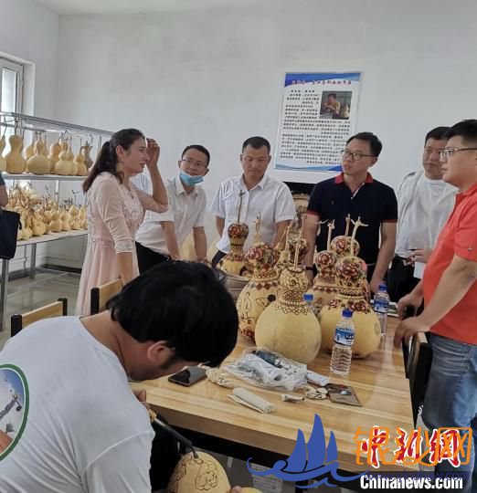 在连队创业园里,吾斯曼·吾布里正专心地烙画,他妻子努力曼姑·库瓦开心地给大家介绍葫芦烙画知识。吉秋霞 摄 在连队创业园里,吾斯曼·吾布里正专心地烙画,他妻子努力曼姑·库瓦开心地给大家介绍葫芦烙画知识。吉秋霞 摄