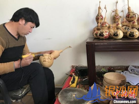 吾斯曼·吾布里专注地在葫芦上勾勒着心中蓝图。吉秋霞 摄 吾斯曼·吾布里专注地在葫芦上勾勒着心中蓝图。吉秋霞 摄