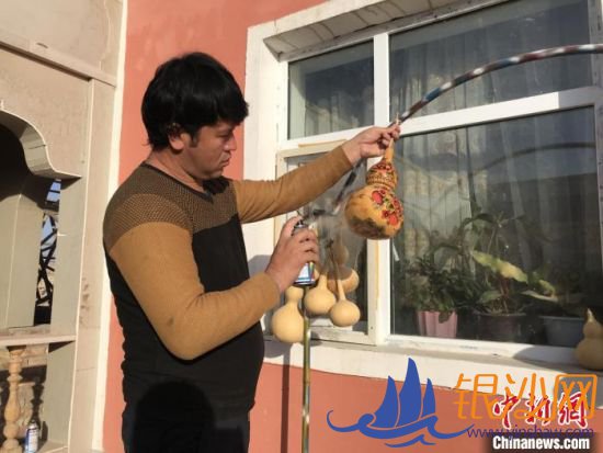 吾斯曼·吾布里在自家院子里晒着太阳,为心爱的葫芦做最后的护色处理。吉秋霞 摄 吾斯曼·吾布里在自家院子里晒着太阳,为心爱的葫芦做最后的护色处理。吉秋霞 摄